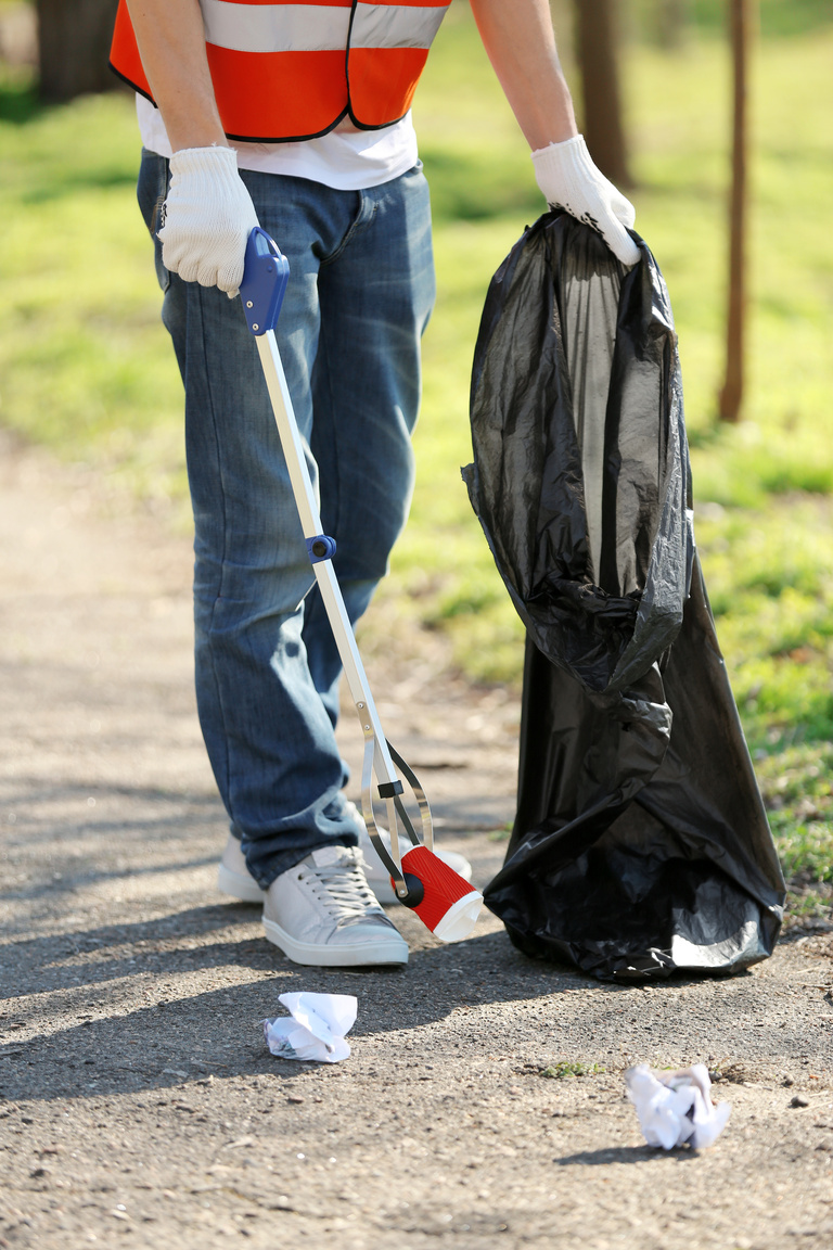Young Volunteer Picking up Litter in Park